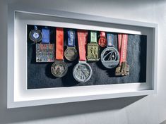 there are many medals on display in the shadow box that is mounted to the wall