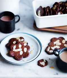 some cookies are sitting on a plate next to a cup of coffee