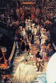 a large group of people standing on top of a boat in the middle of a river