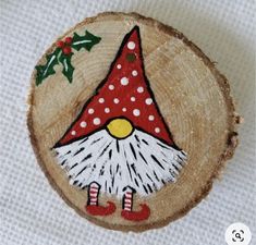 a piece of wood with an image of a gnome's hat on it and holly berries