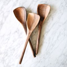 three wooden spoons sitting on top of a marble counter