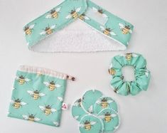 three pieces of cloth with bees on them and one piece of hair accessories next to it