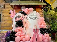 a table with balloons and decorations on it for a birthday party or baby shower in pink, black and white