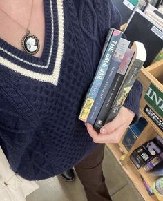 a woman holding several books in her hands