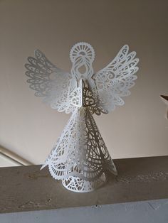 a white paper angel sitting on top of a table