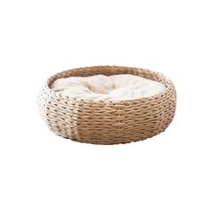 a dog bed made out of wicker with a white blanket in the bottom half