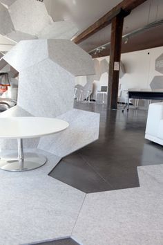 a white table sitting in the middle of a room next to chairs and couches