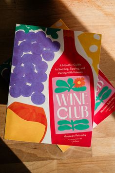 three wine books sitting on top of a wooden table