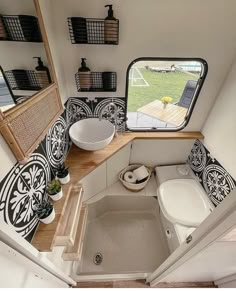 the inside of a tiny bathroom with sink, toilet and shower in it's stall