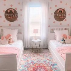 two twin beds in a girls'bedroom with pink and white decor on the walls