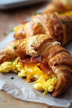 two croissants with bacon and cheese on them