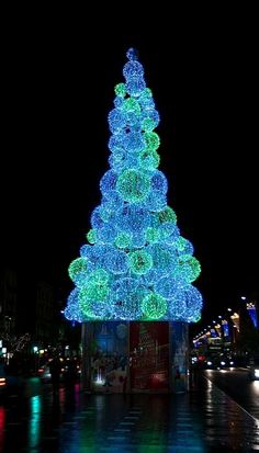 a lit up christmas tree in the middle of a street