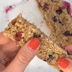 a person holding up a granola bar with fruit on it