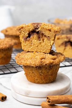 two muffins stacked on top of each other with cinnamon sticks in the background