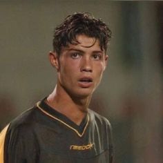 a young man in a soccer uniform looking at the camera with an intense look on his face