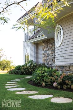 an image of a house with landscaping on the front and side yard, including stone walkways