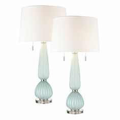 two blue lamps with white shades on them