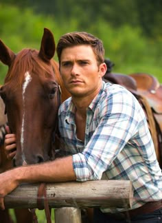 a man leaning on a fence next to a horse