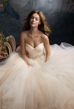 a woman in a wedding dress sitting on the floor