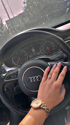 a woman's hand on the steering wheel of a car