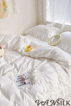 an unmade bed with white sheets, pillows and stuffed animals on the comforter