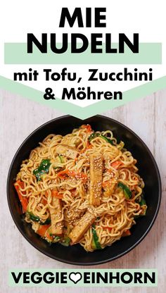 a plate of noodles with meat and vegetables in it on a white wooden table next to the words mie nueden