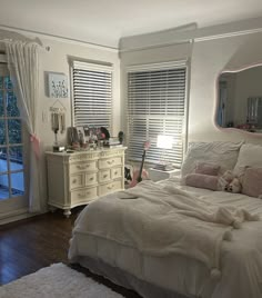 a bedroom with a bed, dresser and mirror