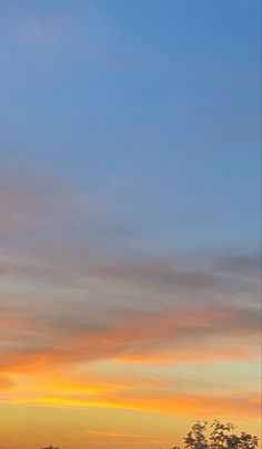 a plane is flying in the sky at sunset