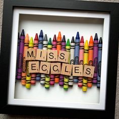 the word miss spelled out with crayons in front of a black framed frame