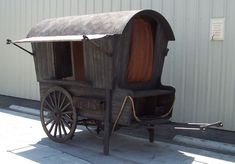 an old fashioned horse drawn carriage parked in front of a building