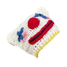 a white crocheted pillow with a red, yellow and blue clown face on it