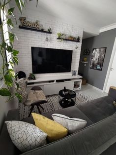 a living room filled with furniture and a flat screen tv mounted on a wall above a fireplace