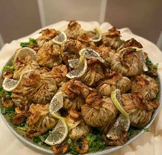 a plate full of food with lemons and other foods on it, sitting on a table