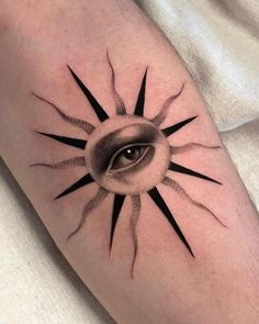 a black and white tattoo with an eye in the center