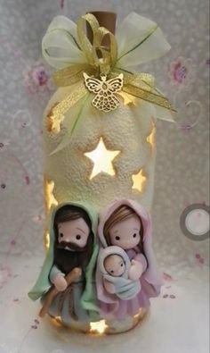 a lighted nativity candle with two figurines in it