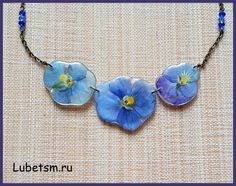 two blue flowers are attached to a necklace