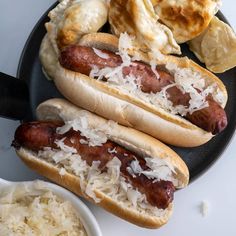 two hotdogs with sauerkraut and other food items