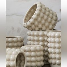 several white vases stacked on top of each other