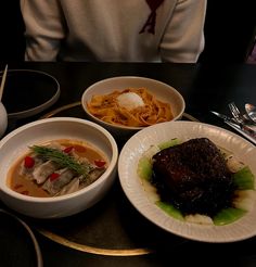 three plates of food on a black table