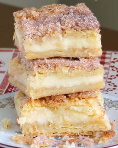 three pieces of cake sitting on top of a red and white plate with the words, simple cheesecake bars