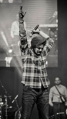 a man standing on top of a stage with his arms in the air