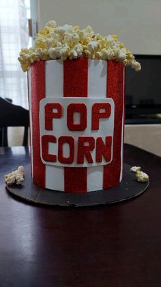 a red and white popcorn bucket sitting on top of a table