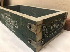 an old wooden crate with some writing on it's sides and the lid open