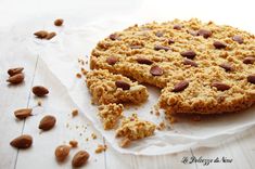 a close up of a cookie on a piece of paper with almonds around it