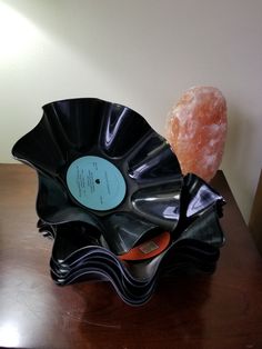 a black record player sitting on top of a wooden table next to a donut