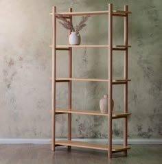 a wooden shelf with two vases on it