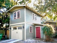 a two story house with red doors and windows