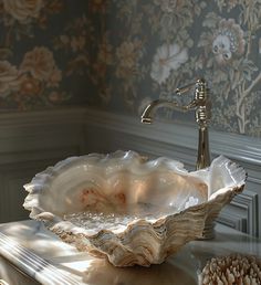 a bathroom sink sitting on top of a counter next to a flowered wall paper