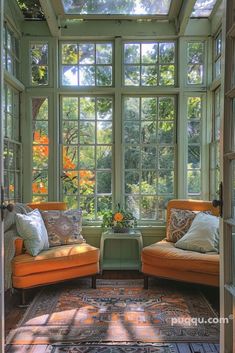 two orange chairs sitting in front of a window with lots of windows on each side