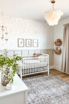 a baby's room with a crib, rug and pictures on the wall